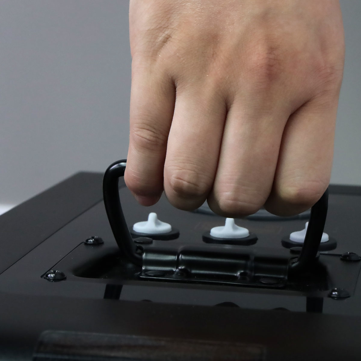 Hand gripping the spring-loaded handle on top of the Revive Hydrogen generator