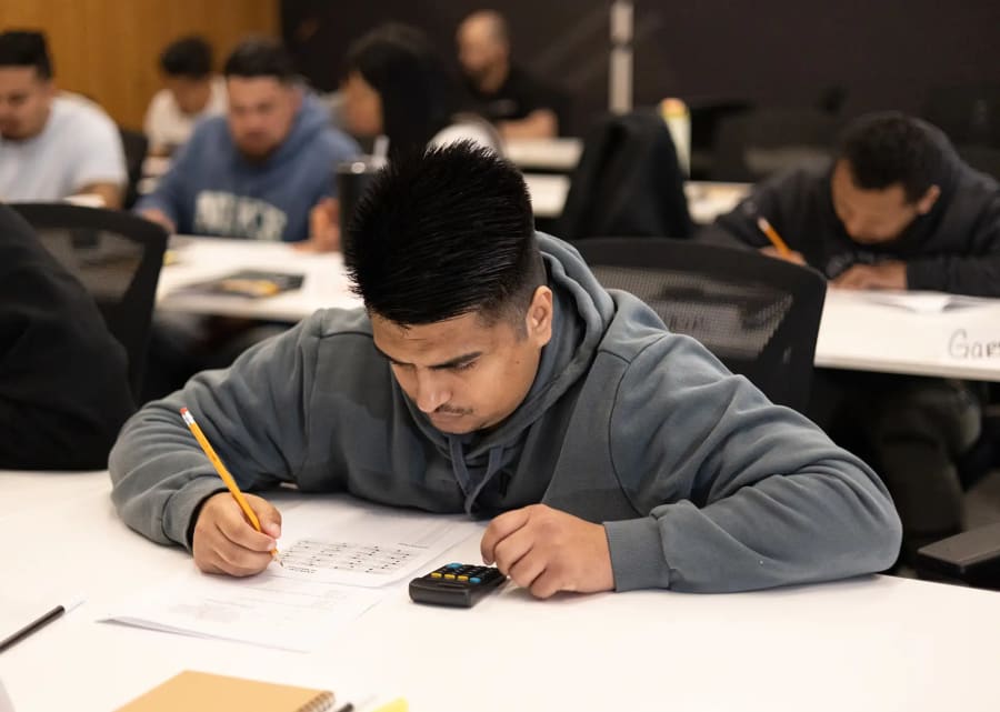 Roofing student taking notes during class.