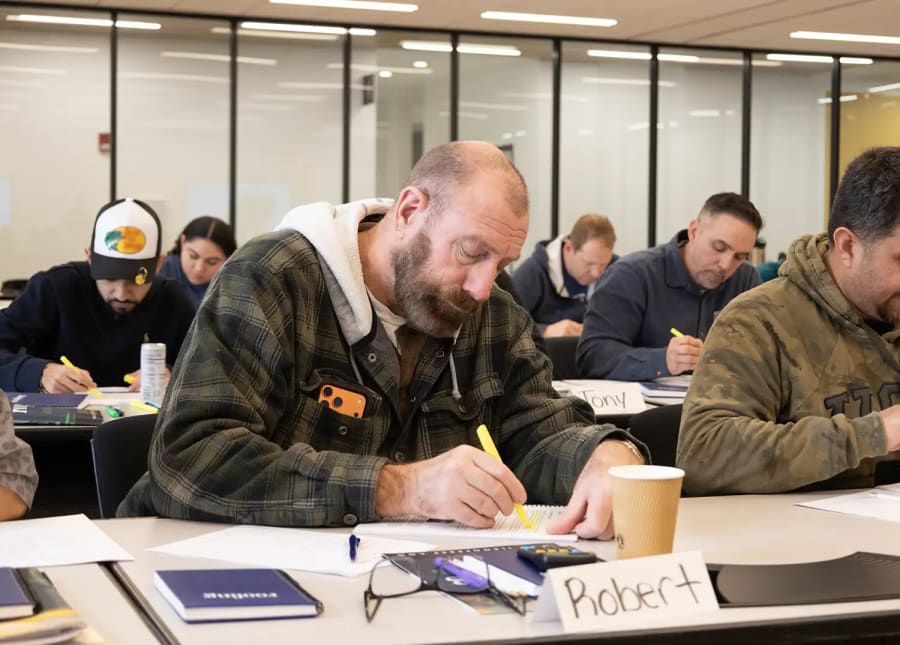 Roofer taking notes in class.