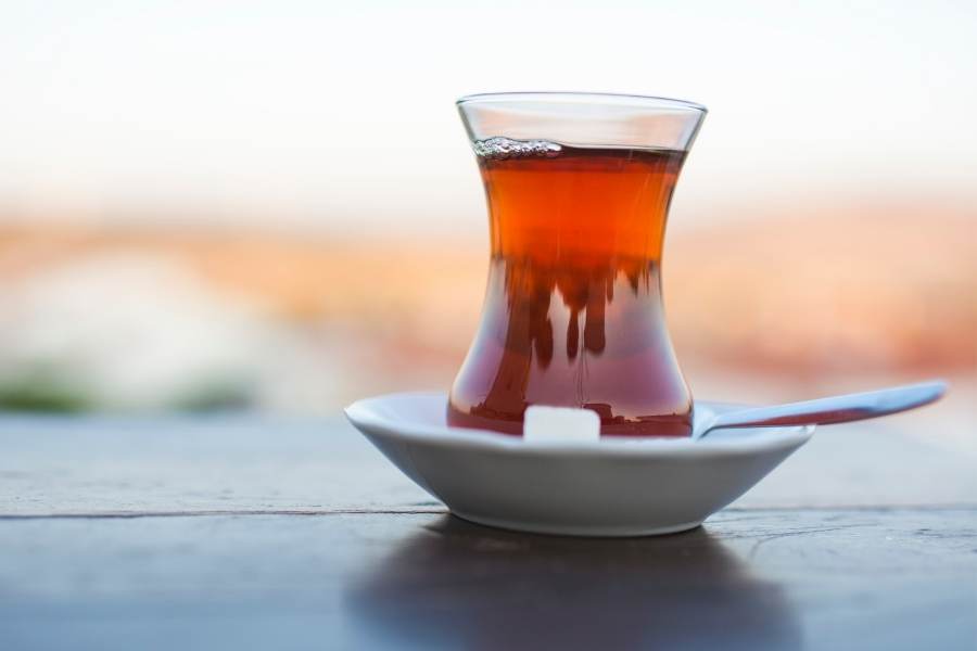 a glass of turkish tea with one sugar cube