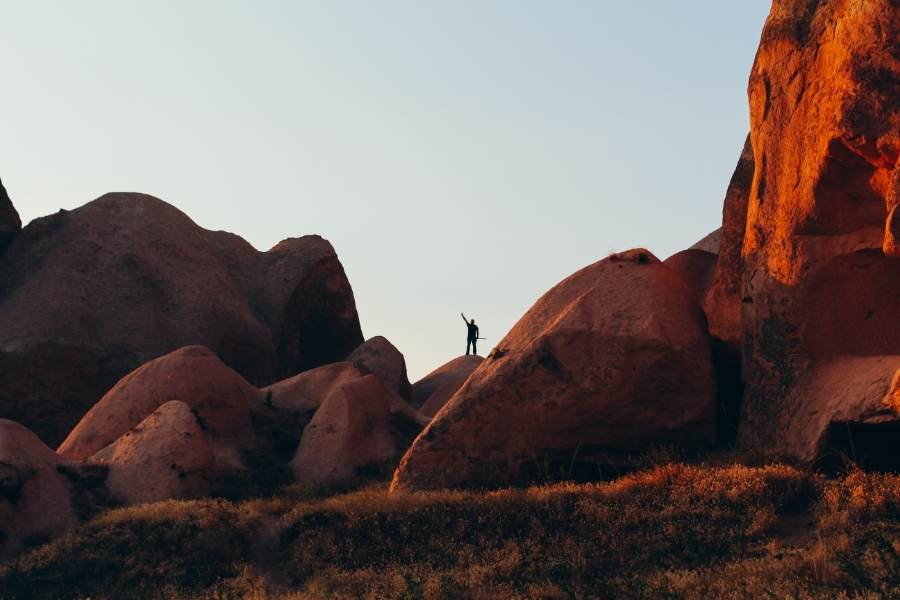 silhouette of a man waving at cappadocia valley in turkey