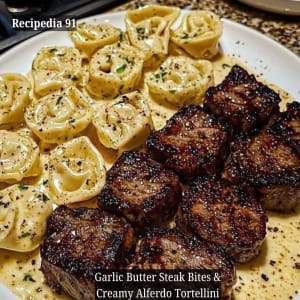 Garlic Butter Steak Bites and Creamy Alfredo Tortellini - a closeup image of the finished dish on the plate.