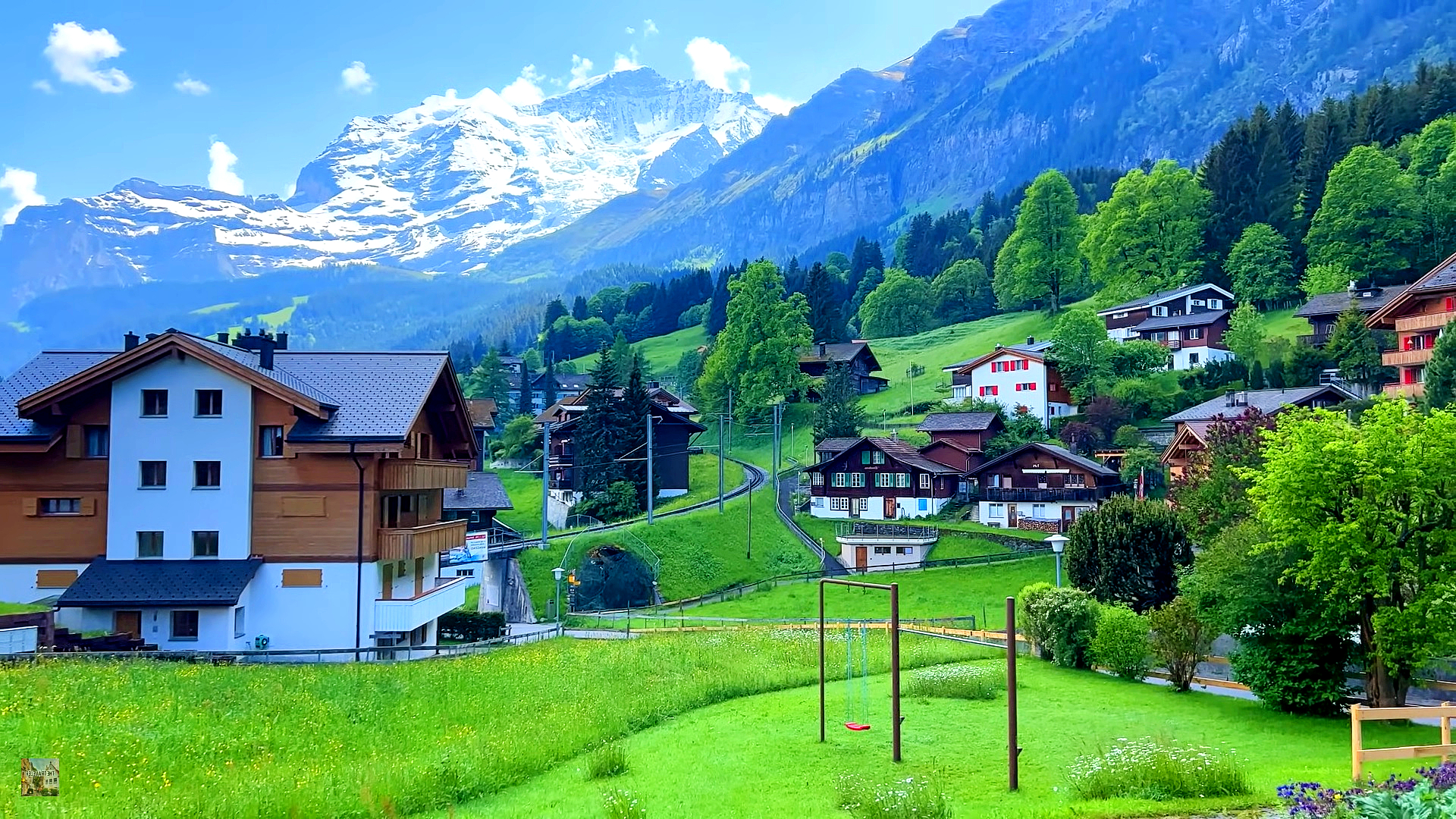 A breathtaking aerial view of a lake surrounded by mountains and a picturesque village in Switzerland.