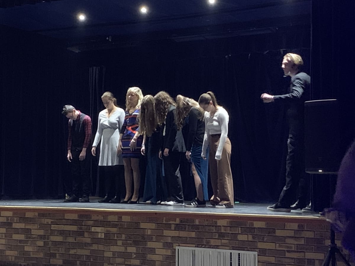 Volontaires sur scène lors d'un spectacle d'hypnose, réactions authentiques