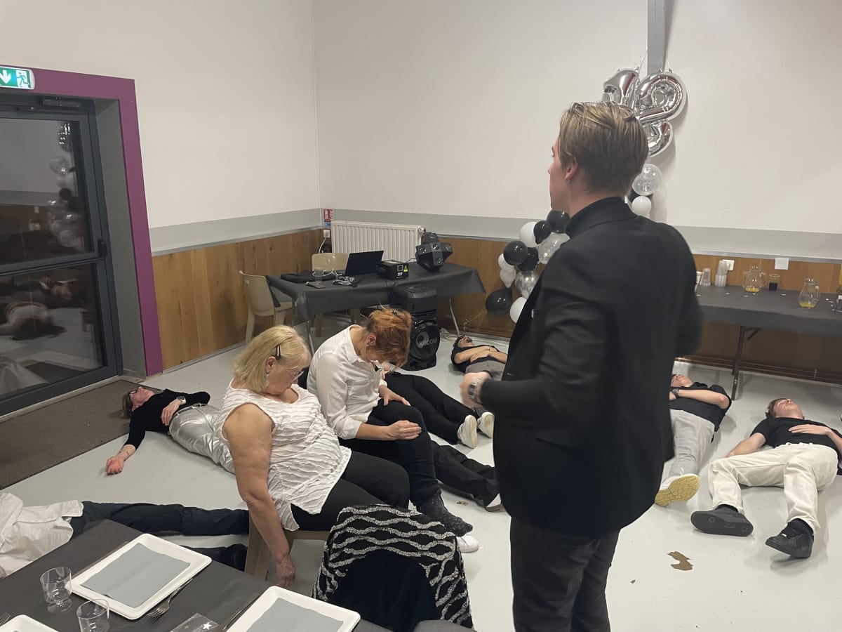 Volontaires assis lors d'un spectacle d'hypnose d'anniversaire en salle des fêtes