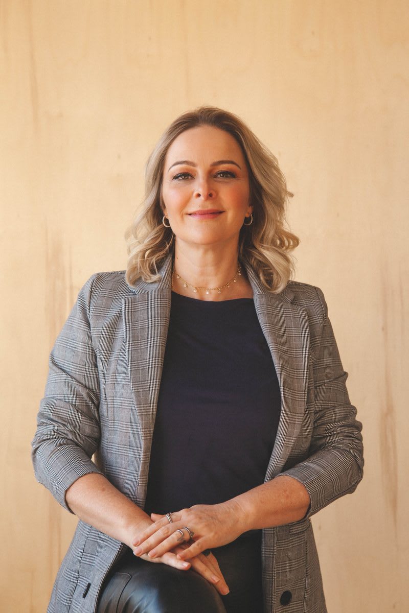 Retrato de Juliane Bach, de blazer, com olhar acolhedor e direto