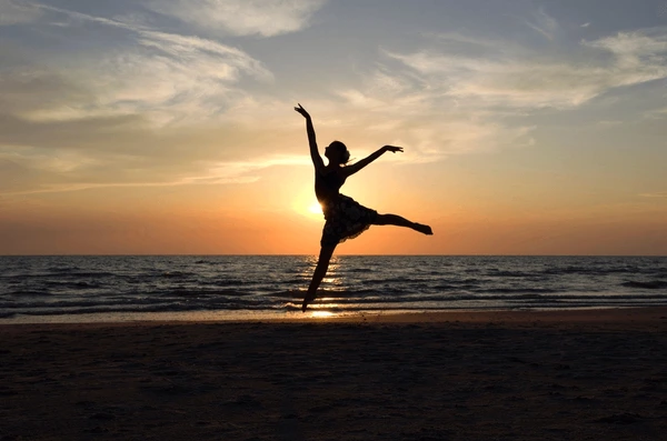 Person celebrating freedom at sunrise