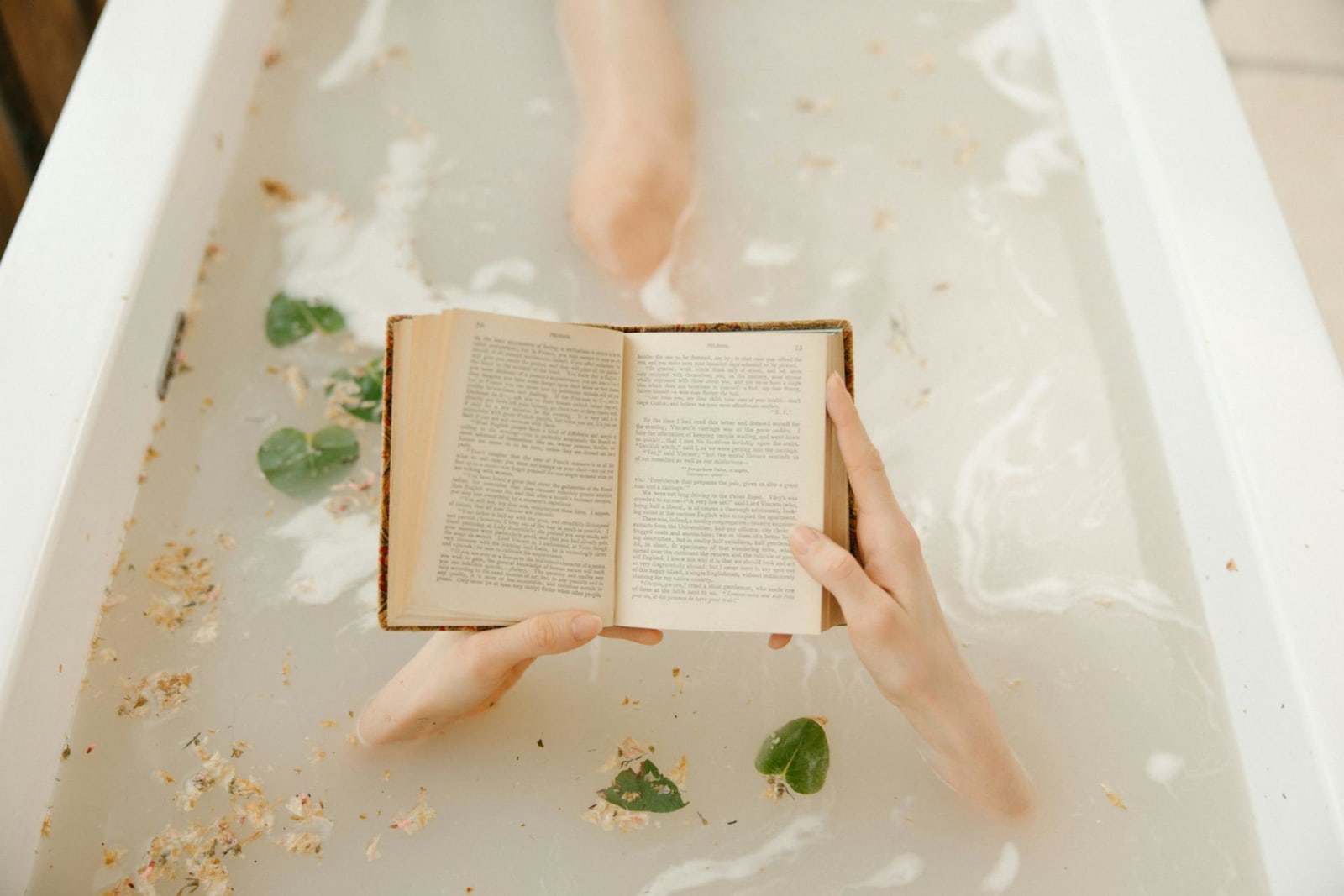 Person in a bathtub reading a book