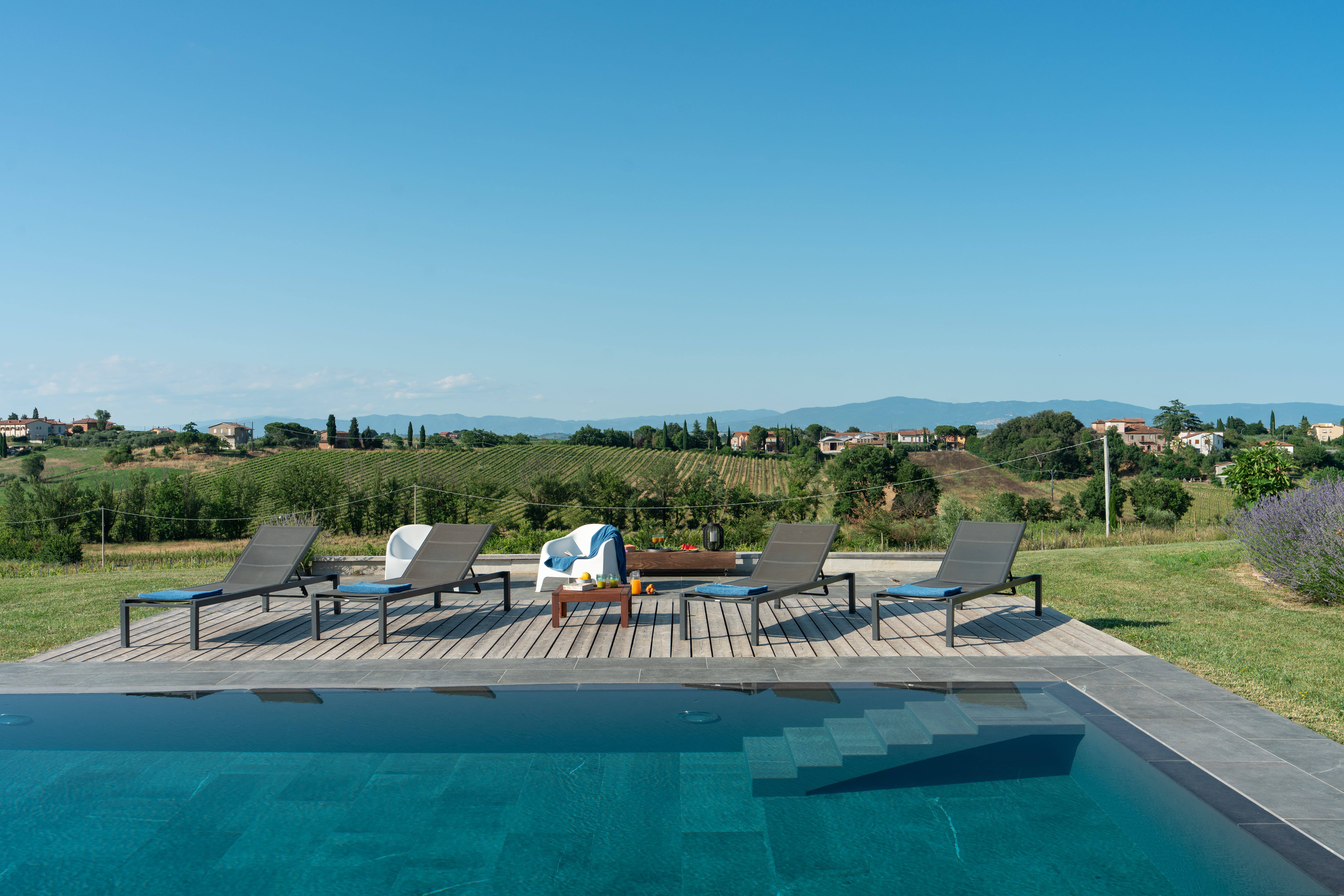 Tuscan villa pool deck with loungers — luxury pool management by MANERI