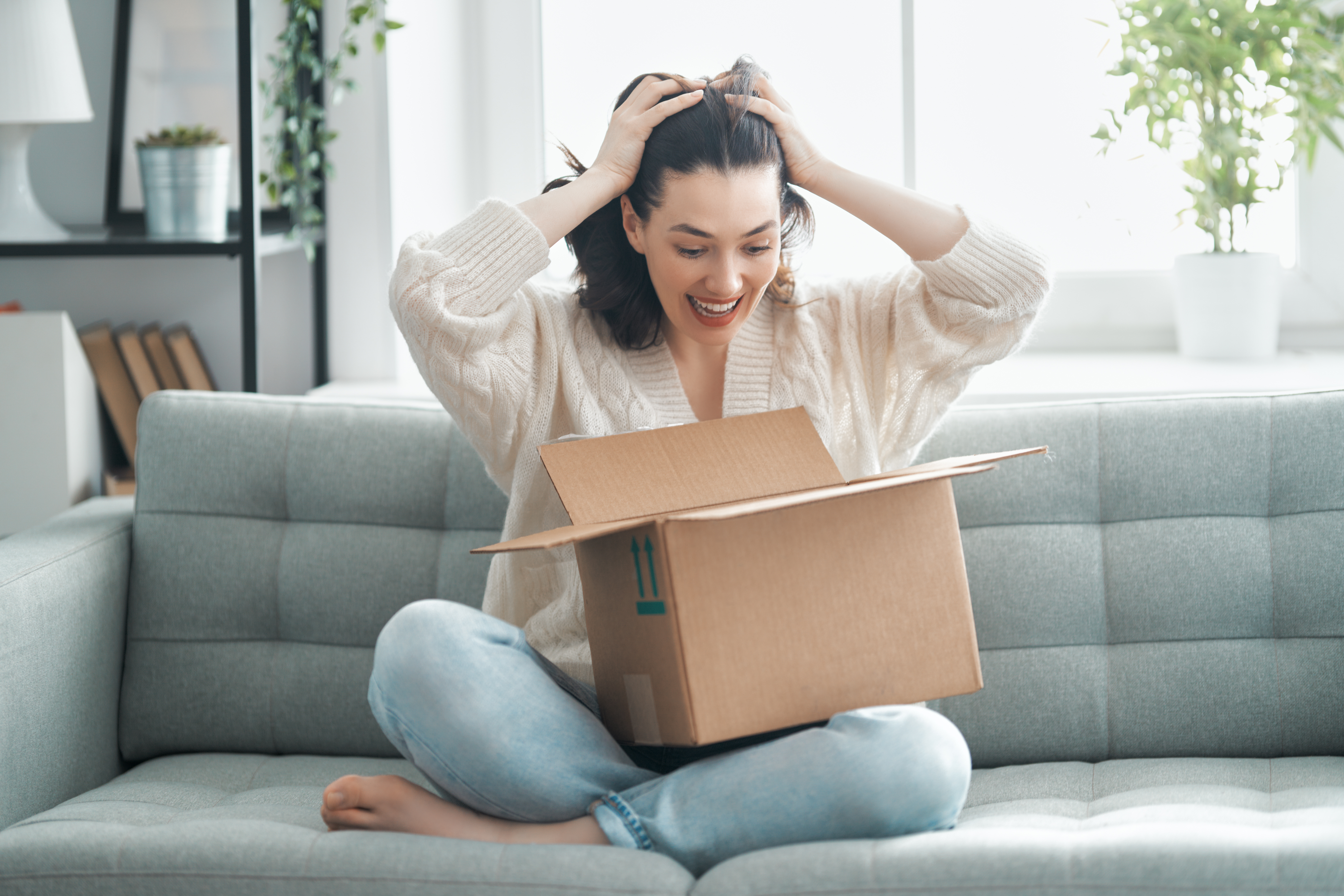 Happy woman opening product delivery at home