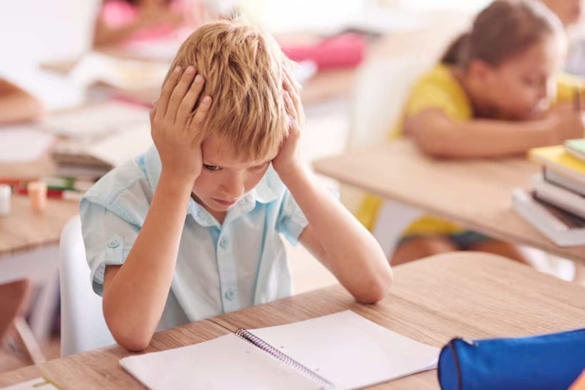 A young student looking frustrated with schoolwork.