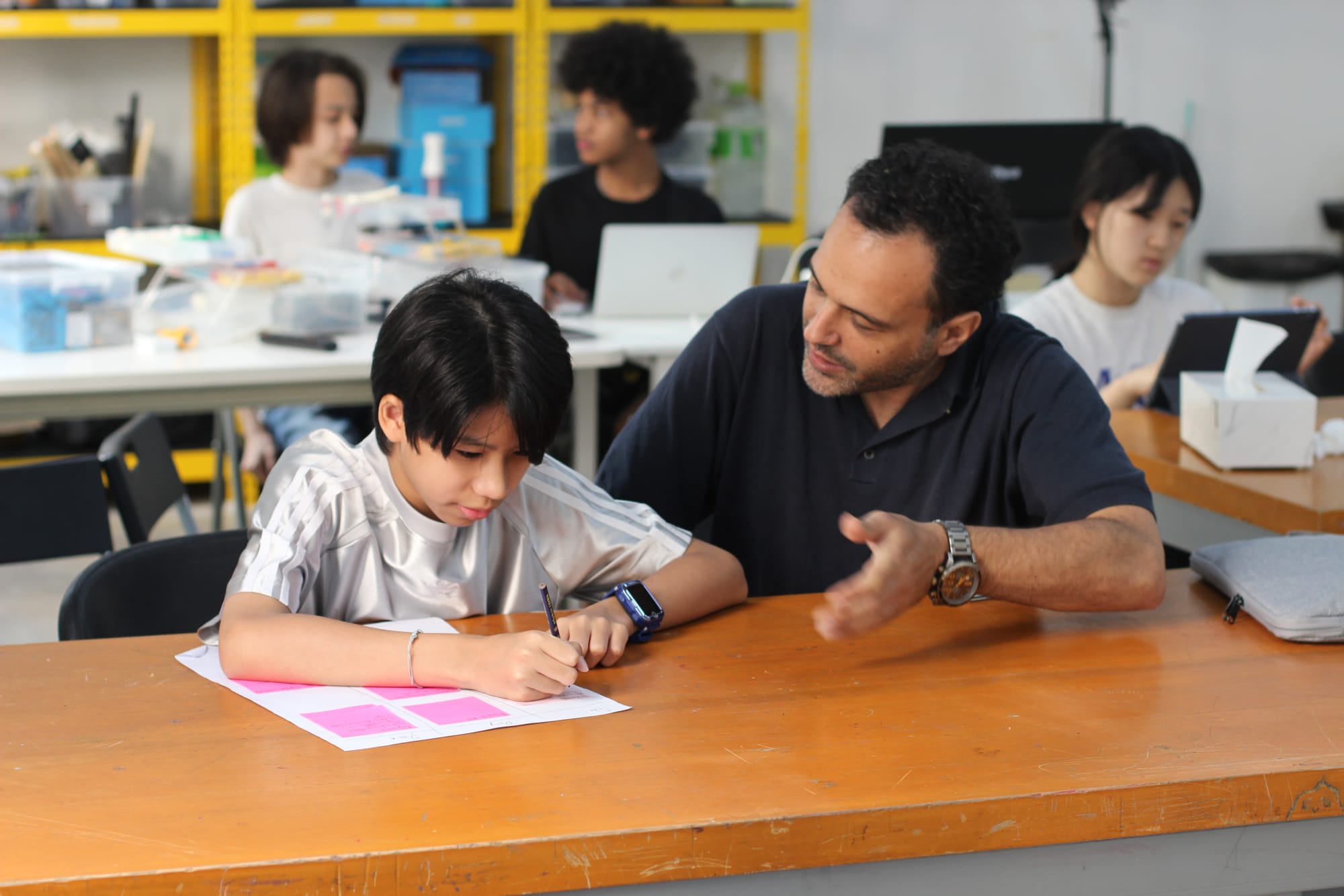 Coach Mani guiding WeLearn students in programming and digital projects