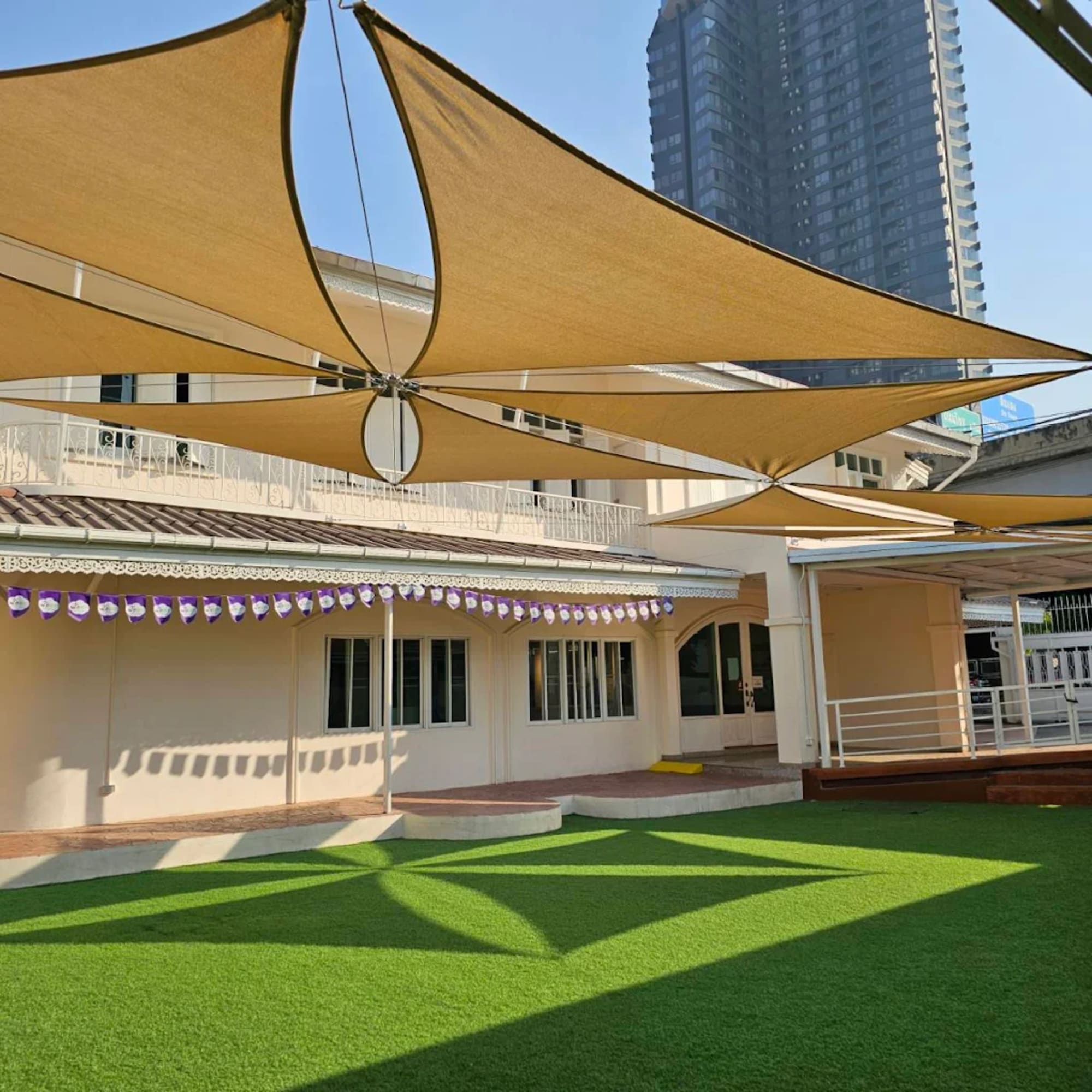 The open WeLearn campus courtyard under its shade sails