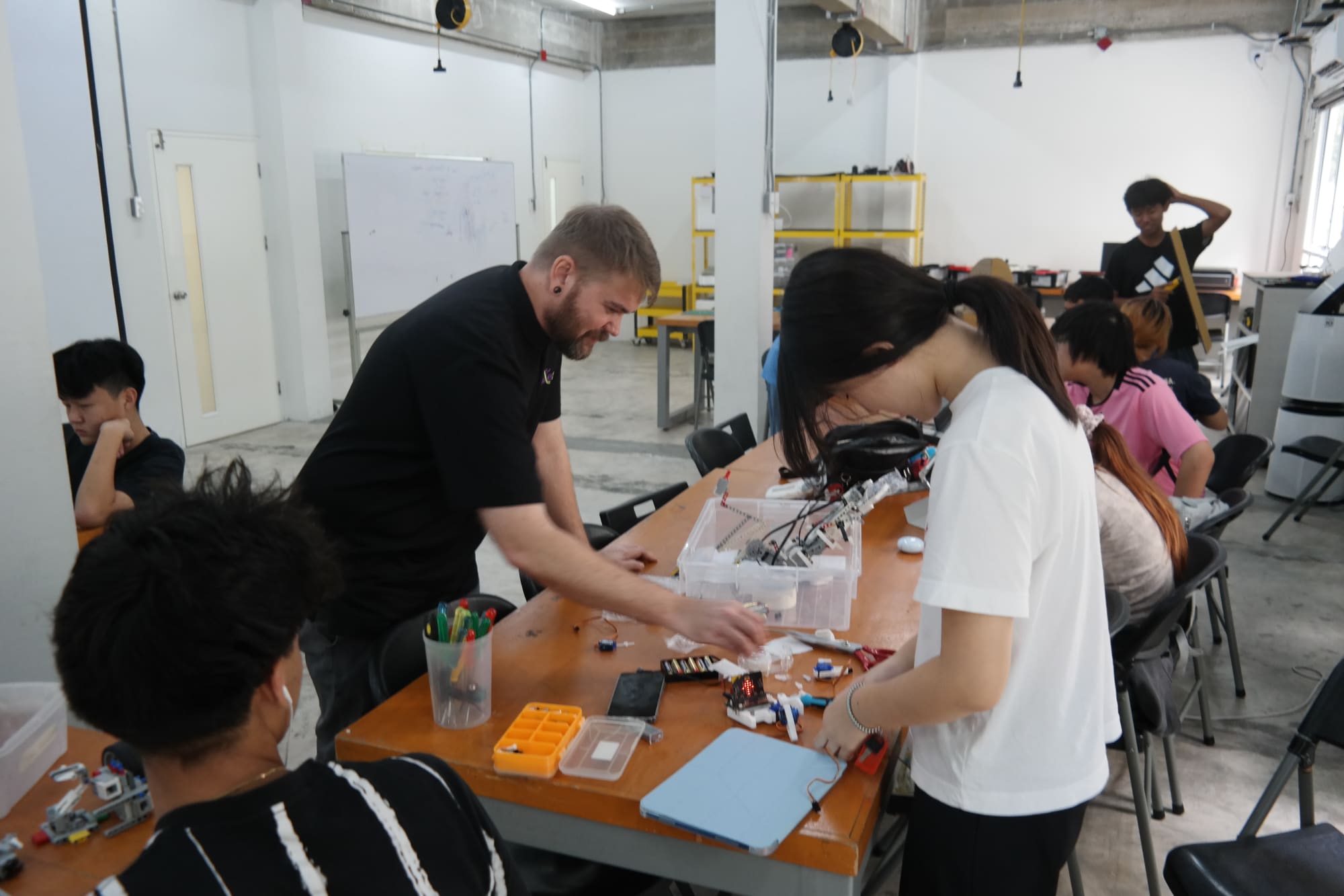 WeLearn learners and mentor collaborating on a hands-on project at the workshop table