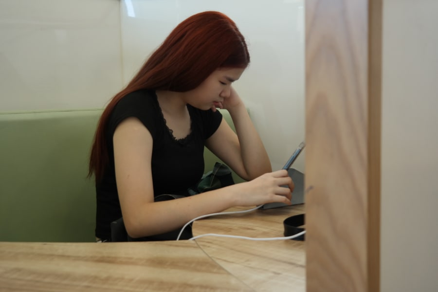A learner focused on her work in a calm private nook.