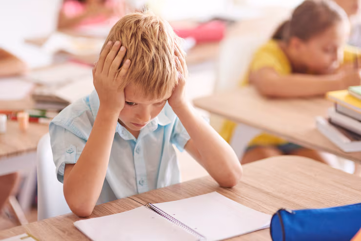 A young student looking frustrated with schoolwork.