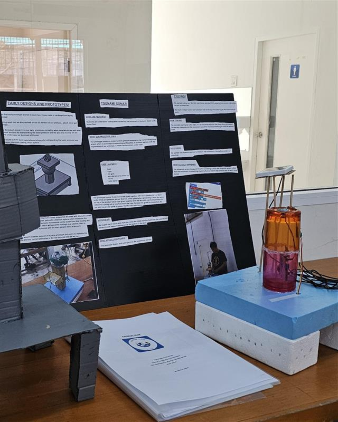 A student engineering project board with built prototypes and written documentation