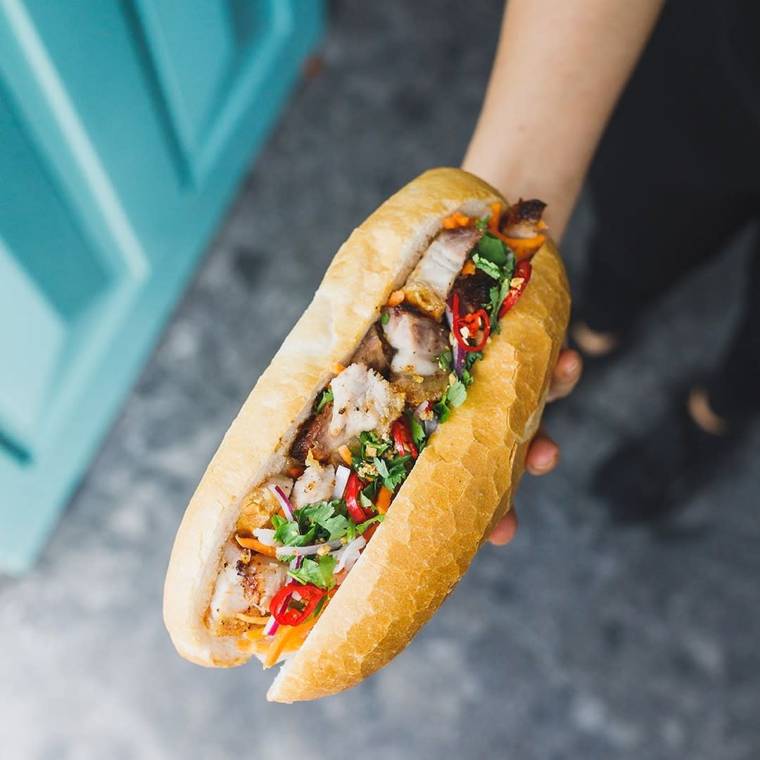 Crispy roast pork banh mi with pickled vegetables and coriander.