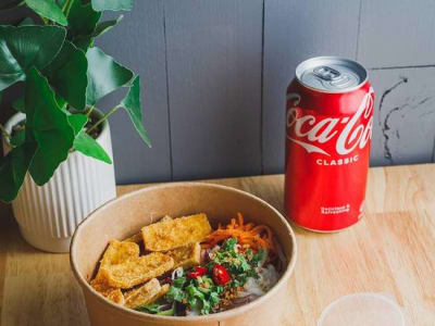 Cabbage bun bowl served with spring rolls or dim sims and a can of drink.