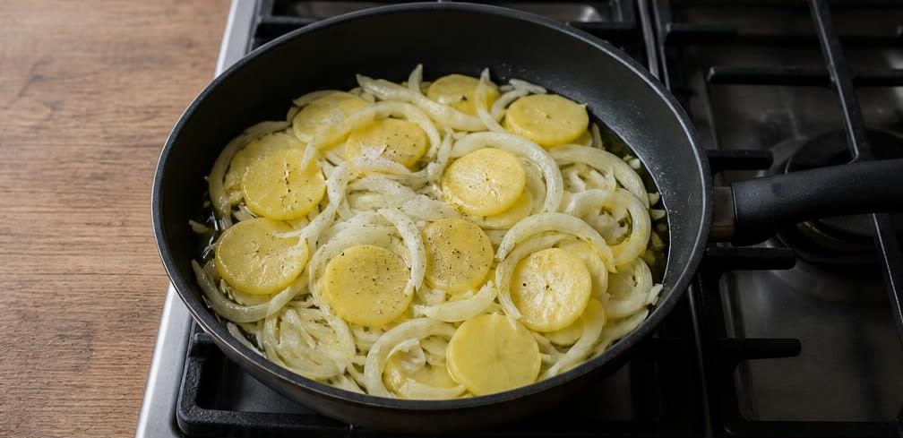 Klassische Tortilla Española mit sanft gestocktem Ei – Zubereitung Schritt für Schritt – Kartoffeln und Zwiebeln garen