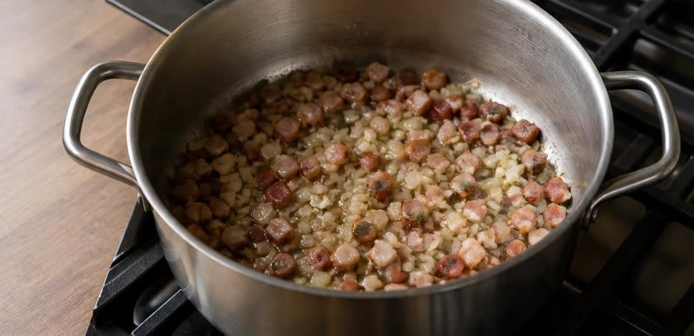 Klassische deutsche Linsensuppe aus eingeweichten Linsen – Zubereitung Schritt für Schritt – Speck auslassen und Zwiebeln dünsten