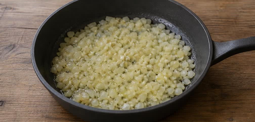 Griechischer Kabeljau in geschmorter Tomaten-Kapern-Sauce – Zubereitung Schritt für Schritt – Zwiebeln und Knoblauch anschwitzen