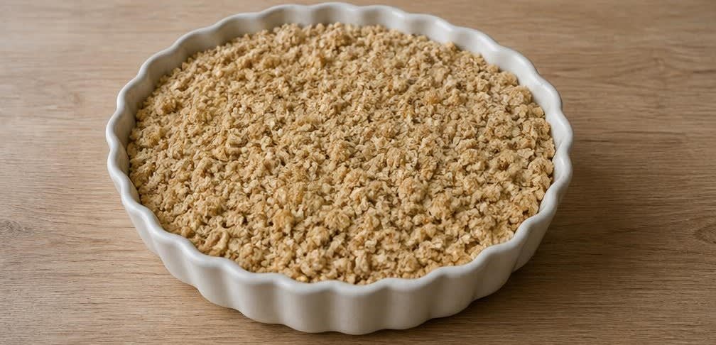 Klassischer britischer Apfel-Crumble mit knusprigen Haferflocken – Zubereitung Schritt für Schritt – Streusel verteilen