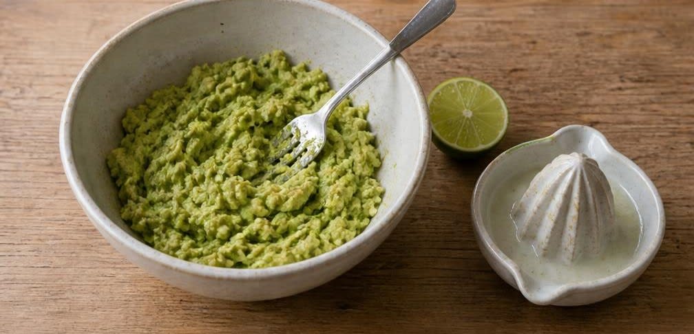 Cremige Guacamole mit frischen Tomatenwürfeln – Zubereitung Schritt für Schritt – Avocados zerdrücken