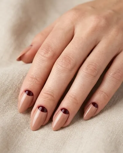 Close-up of almond-shaped nails with a burgundy half-moon crescent at the cuticle area on a nude base, art-deco inspired minimal design Close-up of almond-shaped nails with a burgundy half-moon crescent at the cuticle area on a nude base, art-deco inspired minimal design
