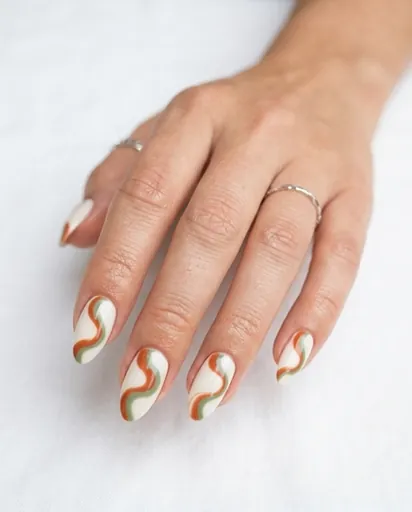 One hand with almond nails featuring bold abstract swirl lines in terracotta and sage green on a cream white base, modern art inspired nail design One hand with almond nails featuring bold abstract swirl lines in terracotta and sage green on a cream white base, modern art inspired nail design