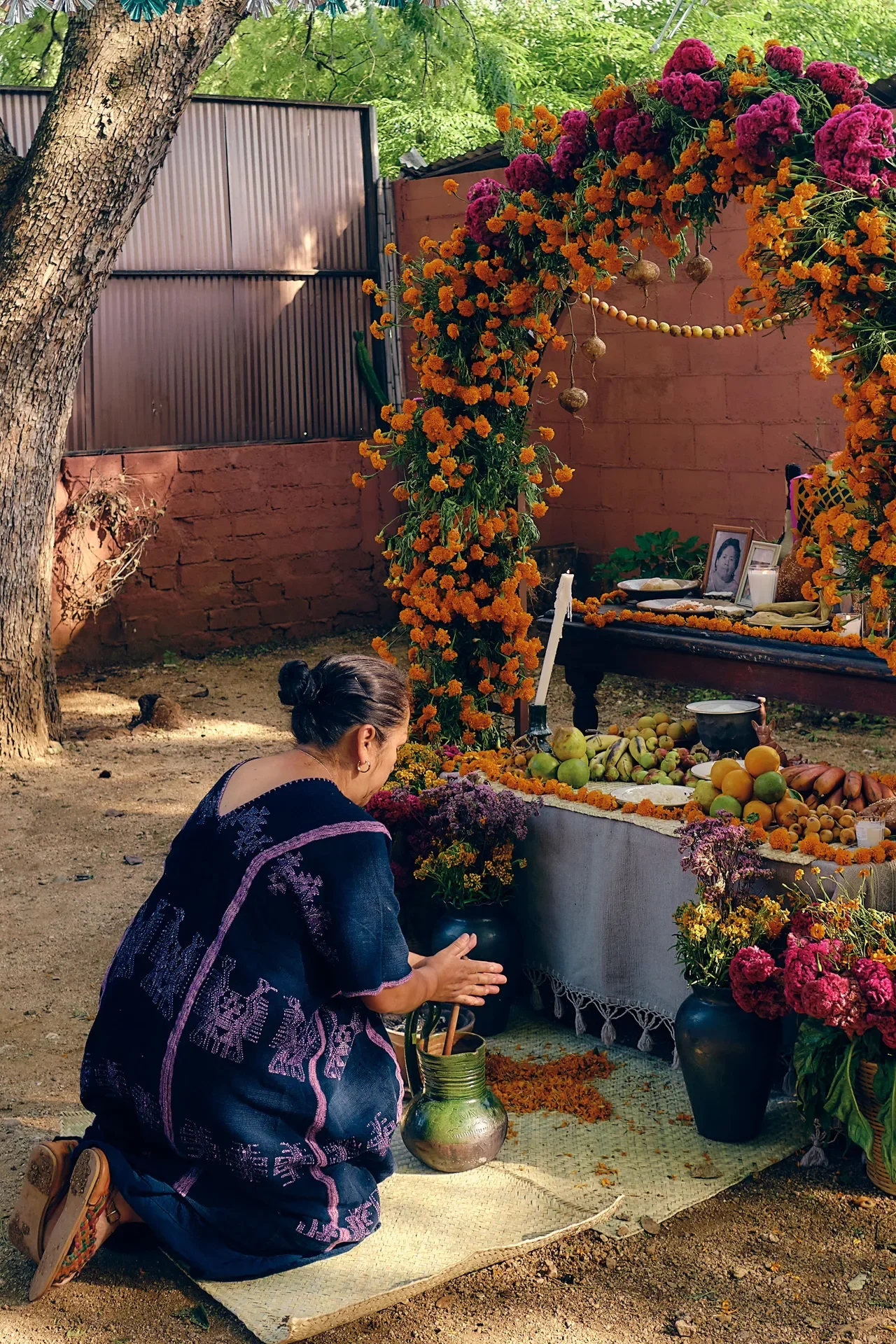A woman preparing a traditional Día de Muertos altar in Oaxaca. Image not property of the author; used for illustrative purposes.