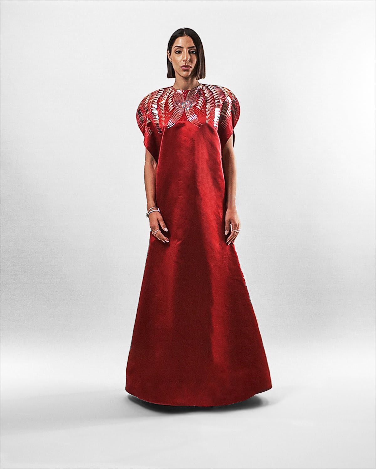 Garnet Silk Gown Tanisha Rada model wearing the in Garnet silk gown, featuring statement shoulders and embellished neckline. front view.