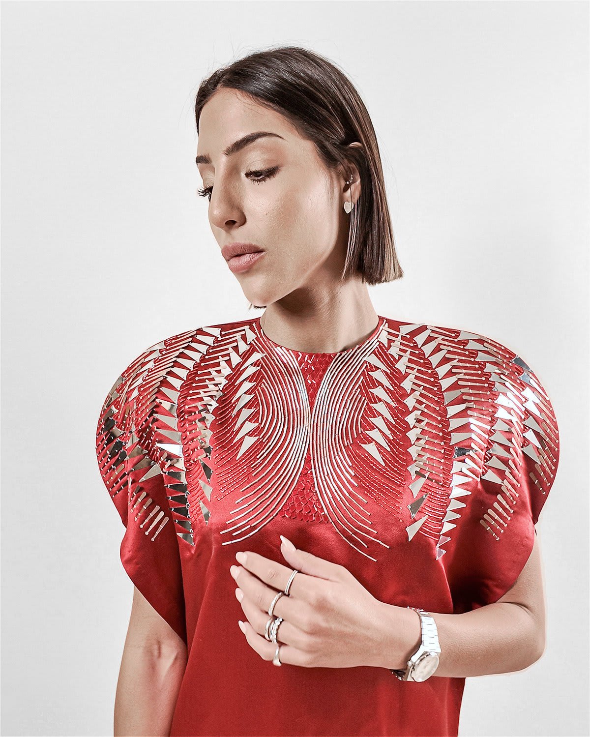 garnet silk gown Tanisha Rada model wearing the in Garnet silk gown, featuring statement shoulders and embellished neckline. close up view.