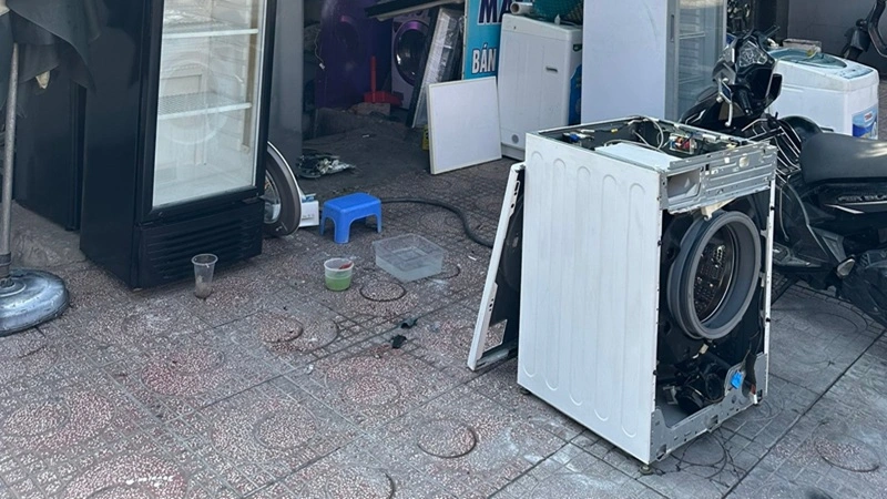 kỹ thuật viên sửa máy giặt cũ sau khi thu mua để tái sử dụng tại Trung Điện Lạnh