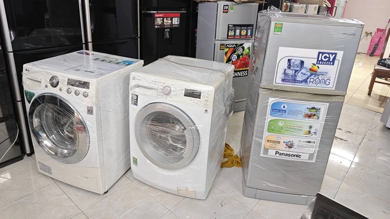 Máy giặt cũ được bọc và lưu trữ trong kho sau khi thu mua tại TP.HCM