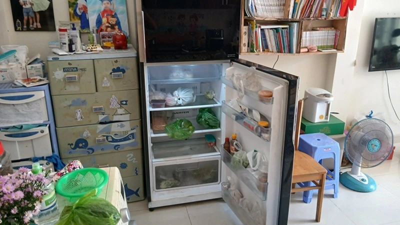 Nhân viên kiểm tra tủ lạnh cũ tại nhà khách Quận 4