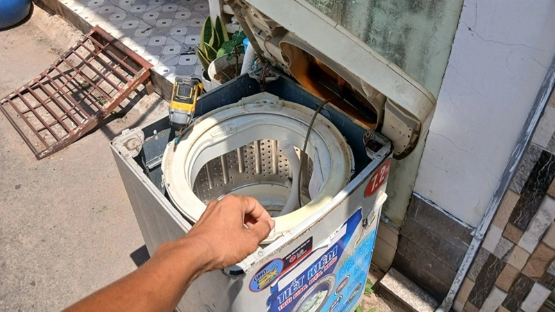 Kỹ thuật viên Trung Điện Lạnh đang kiểm tra lỗi rung mạnh khi vắt của máy giặt LG tại nhà khách Quận 9