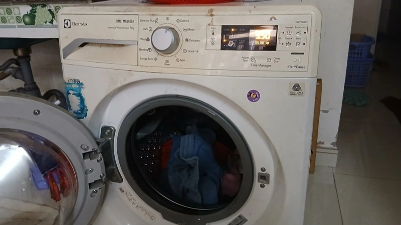 Kỹ thuật viên Trung Điện Lạnh kiểm tra bo mạch máy giặt tại nhà khách hàng ở phường Trường Vinh TP Vinh
