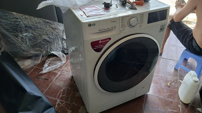 Thợ chuẩn bị sửa máy giặt LG lồng ngang tại nhà khách hàng ở phường Thành Vinh