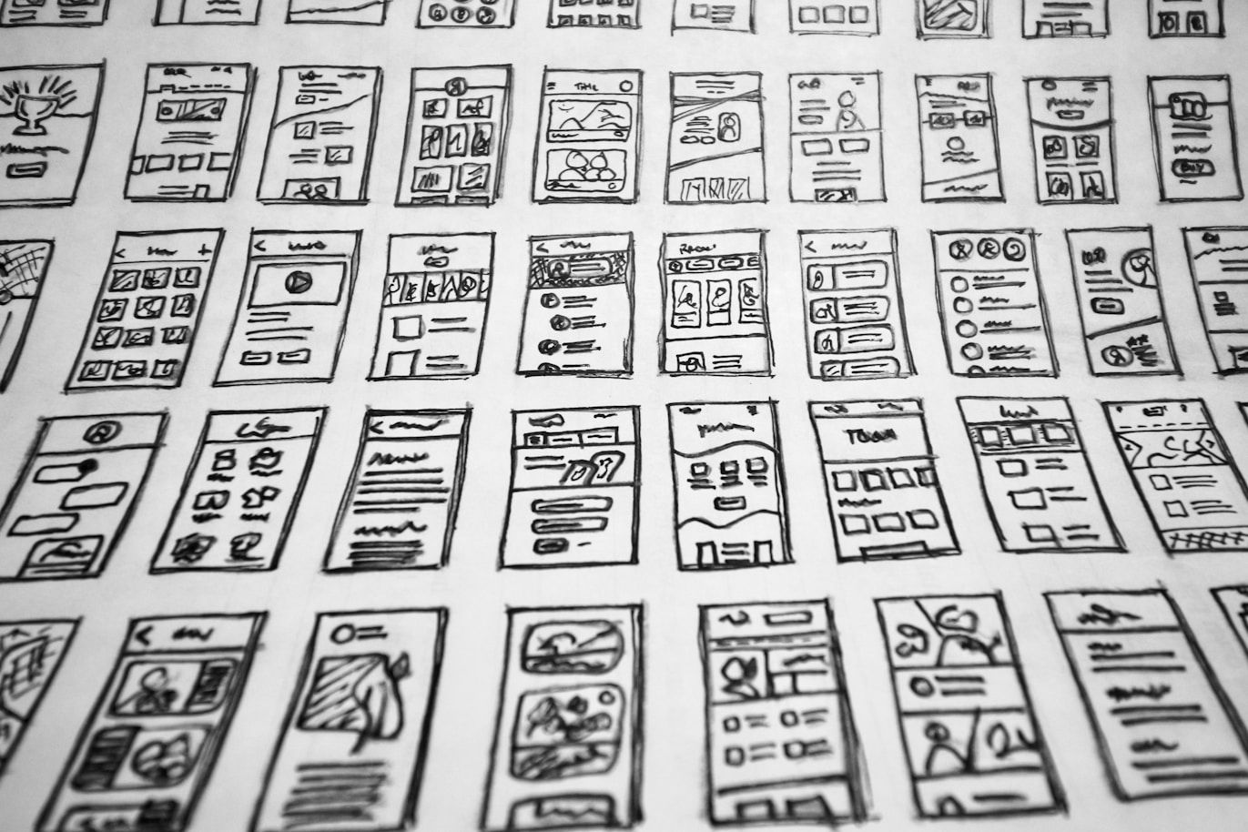 Grid of hand-drawn mobile app user interface wireframes for design conceptualization.