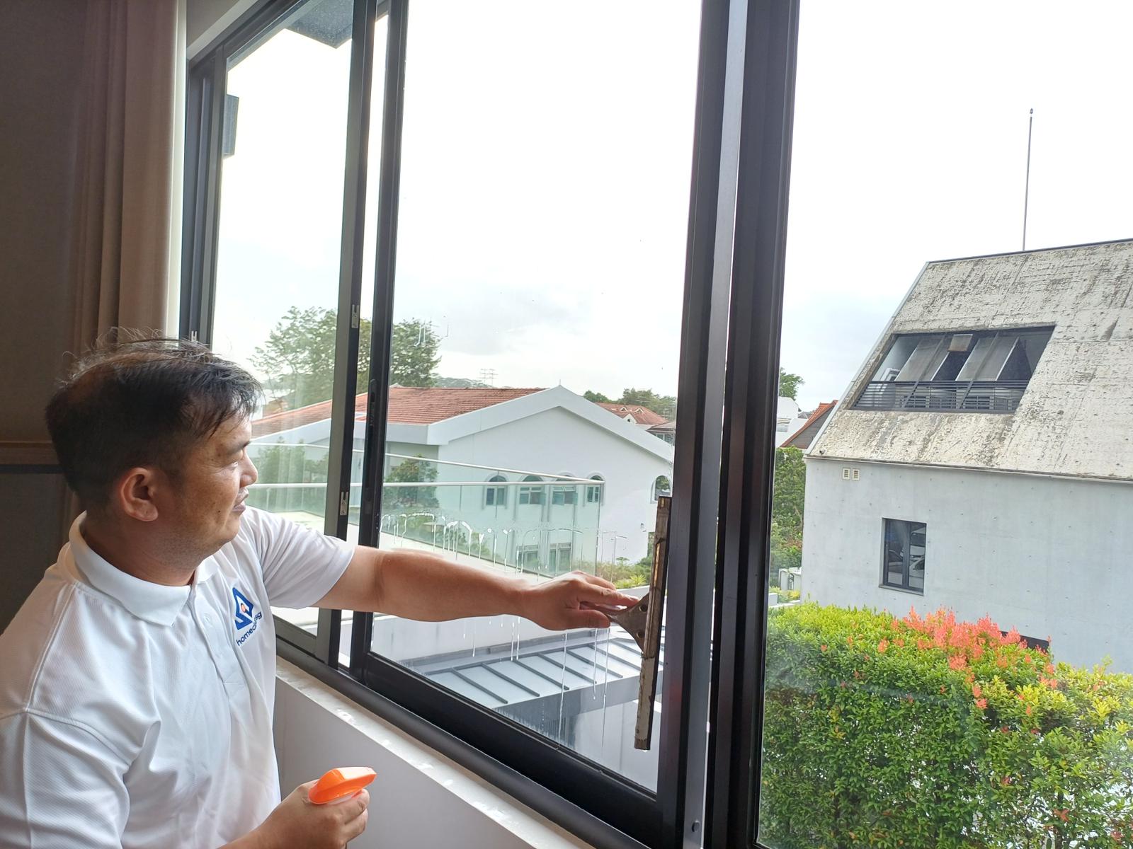 ASC male cleaner wiping windows in Singapore condo