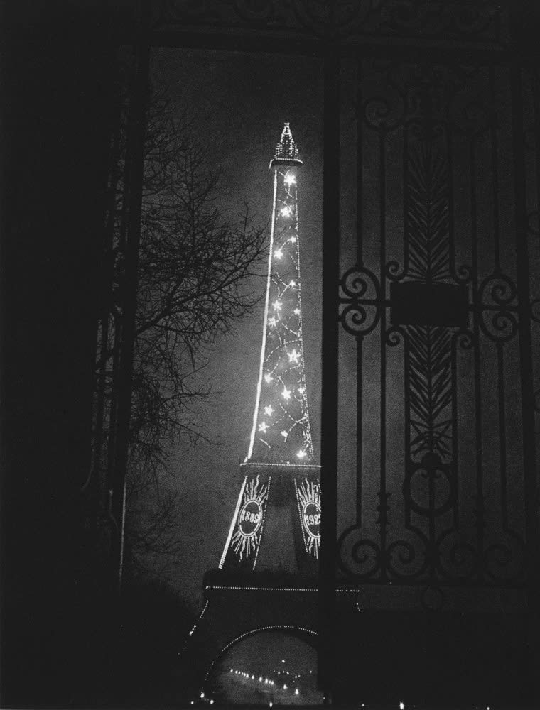 Blazoning the eminence
of Citroén, the Eiffel Tower lights up, framed
in a doorway of the Trocadéro.