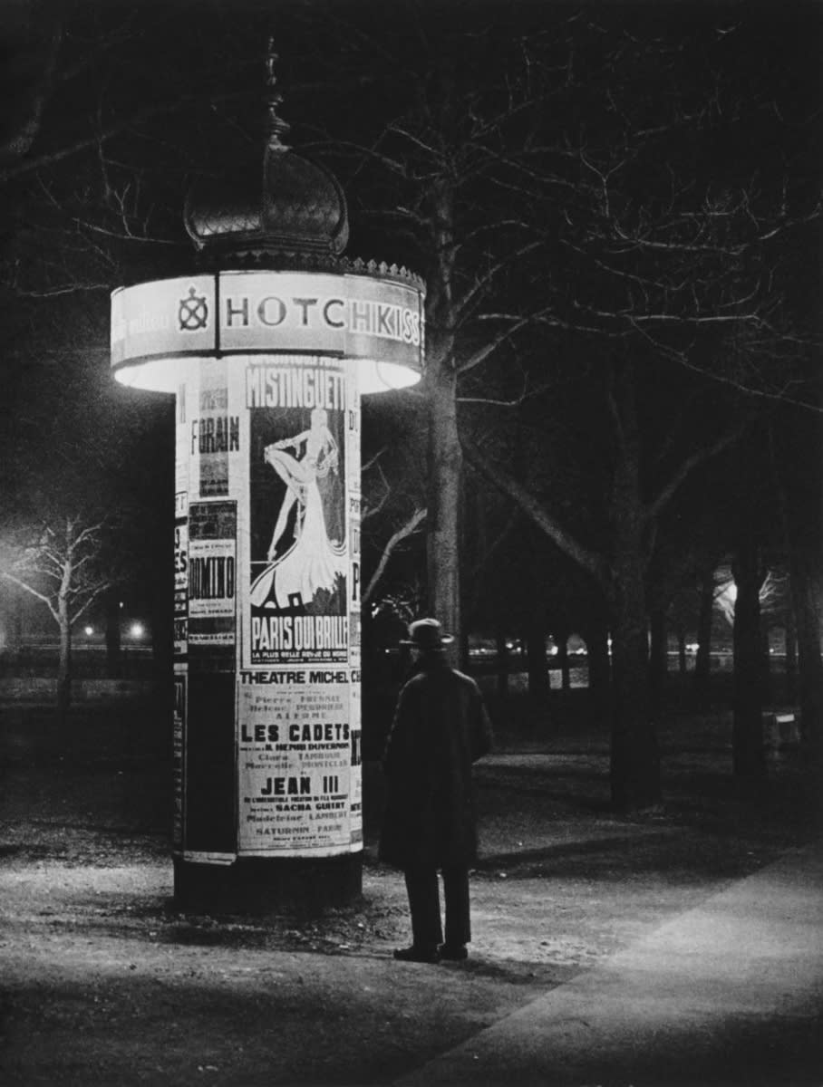 In the subdued light of
a “Morris Pillar” Paris offers its various entertainments, with, as usual, Mistinguett writ large.