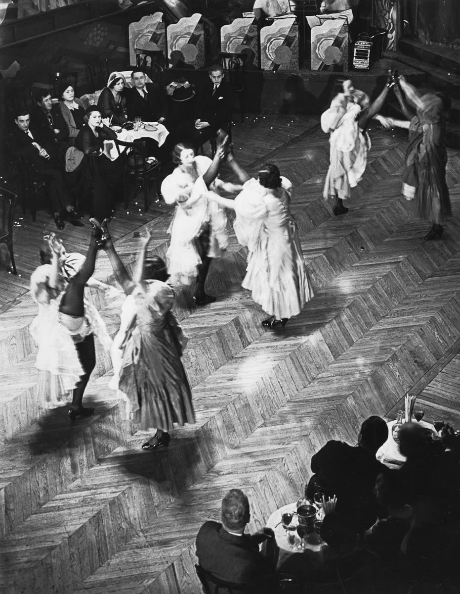 At the Bal Tabarin the
“French Cancan” dancers, in all their pristine glory of black silk stockings, frills and furbelows,...