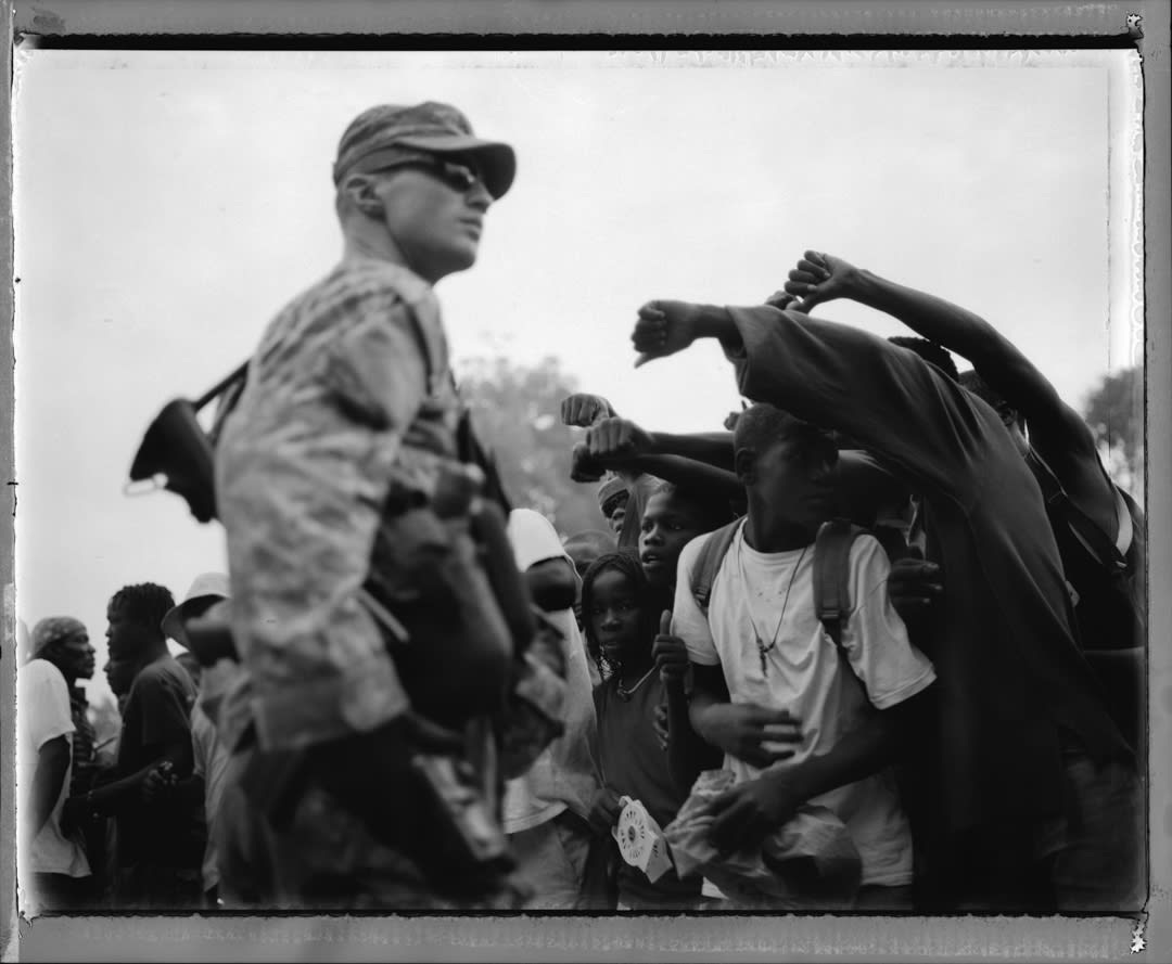 American troops are simultaneously cheered and jeered by Haitian youths on the streets of Port Au Prince two weeks after t...
