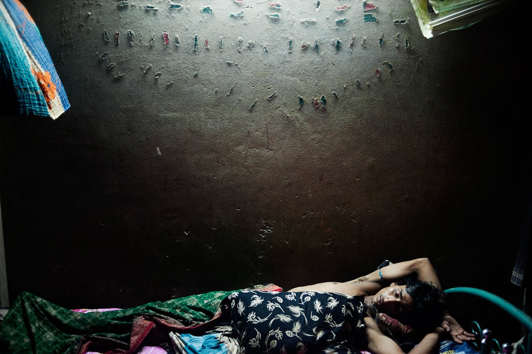 Bangladesh, Dhaka. Abdul is sleeping on his bed. He lives with his family in a small room in the Baunia slum. They moved a...