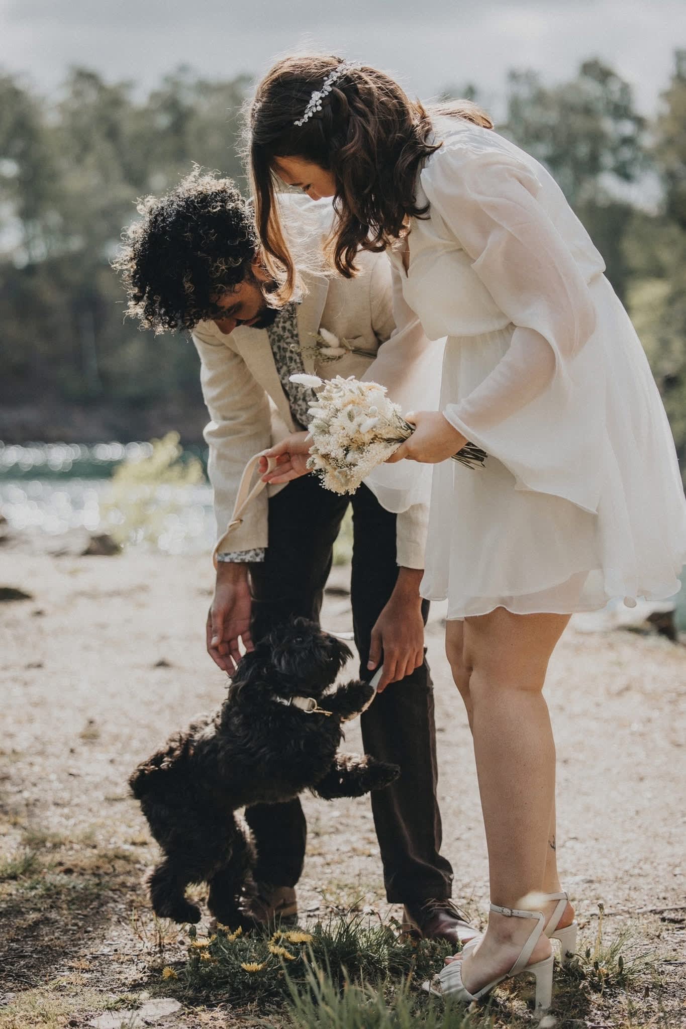 Engagement photo with their dog by the lake