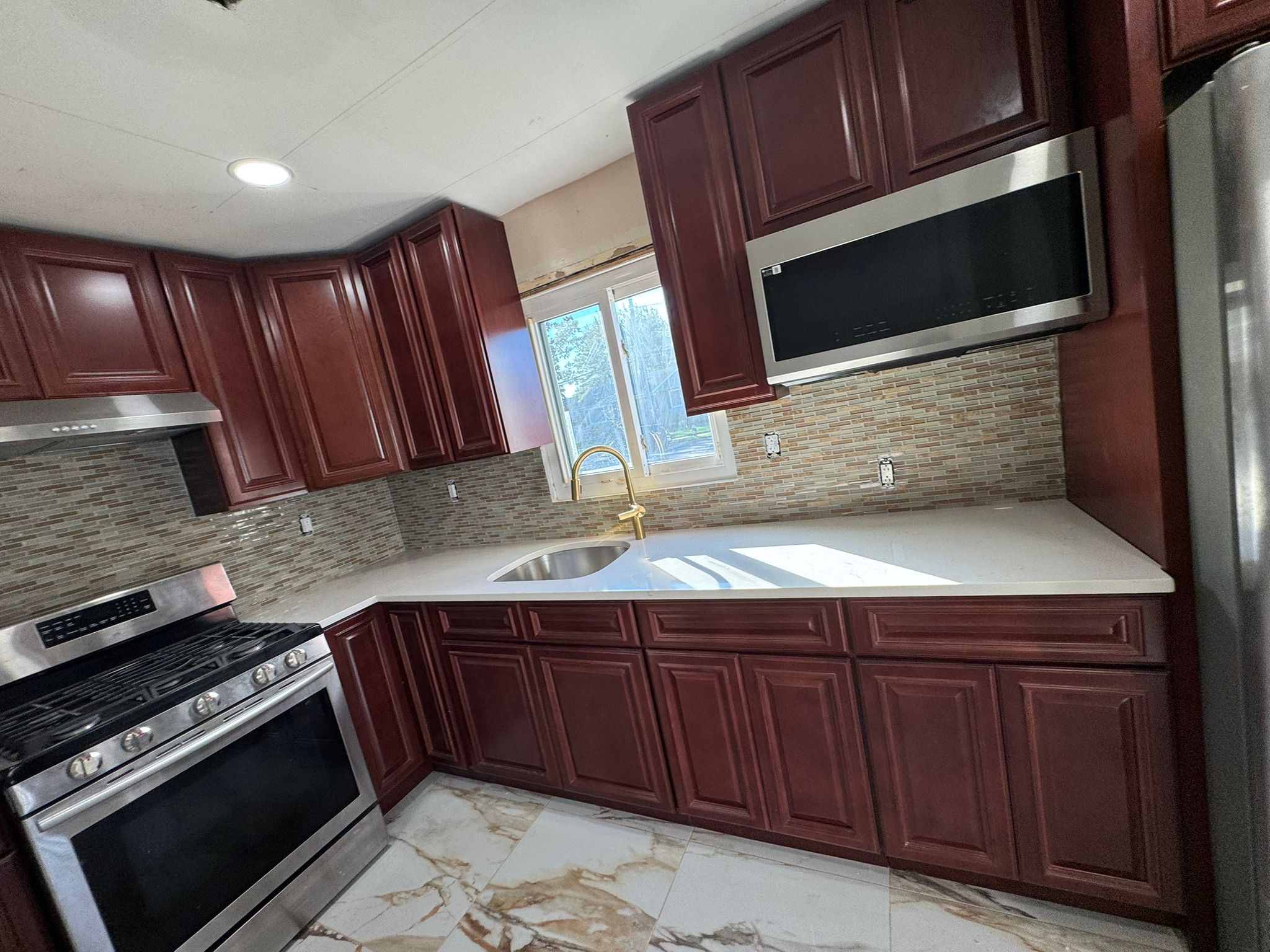Kitchen renovation cherry cabinets quartz counters by Fibinachi Construction