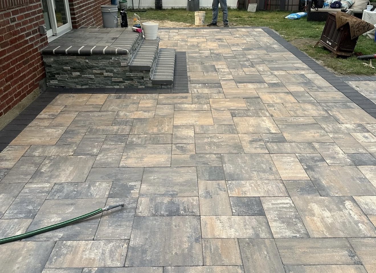 Paver patio with stone steps by Fibinachi Construction