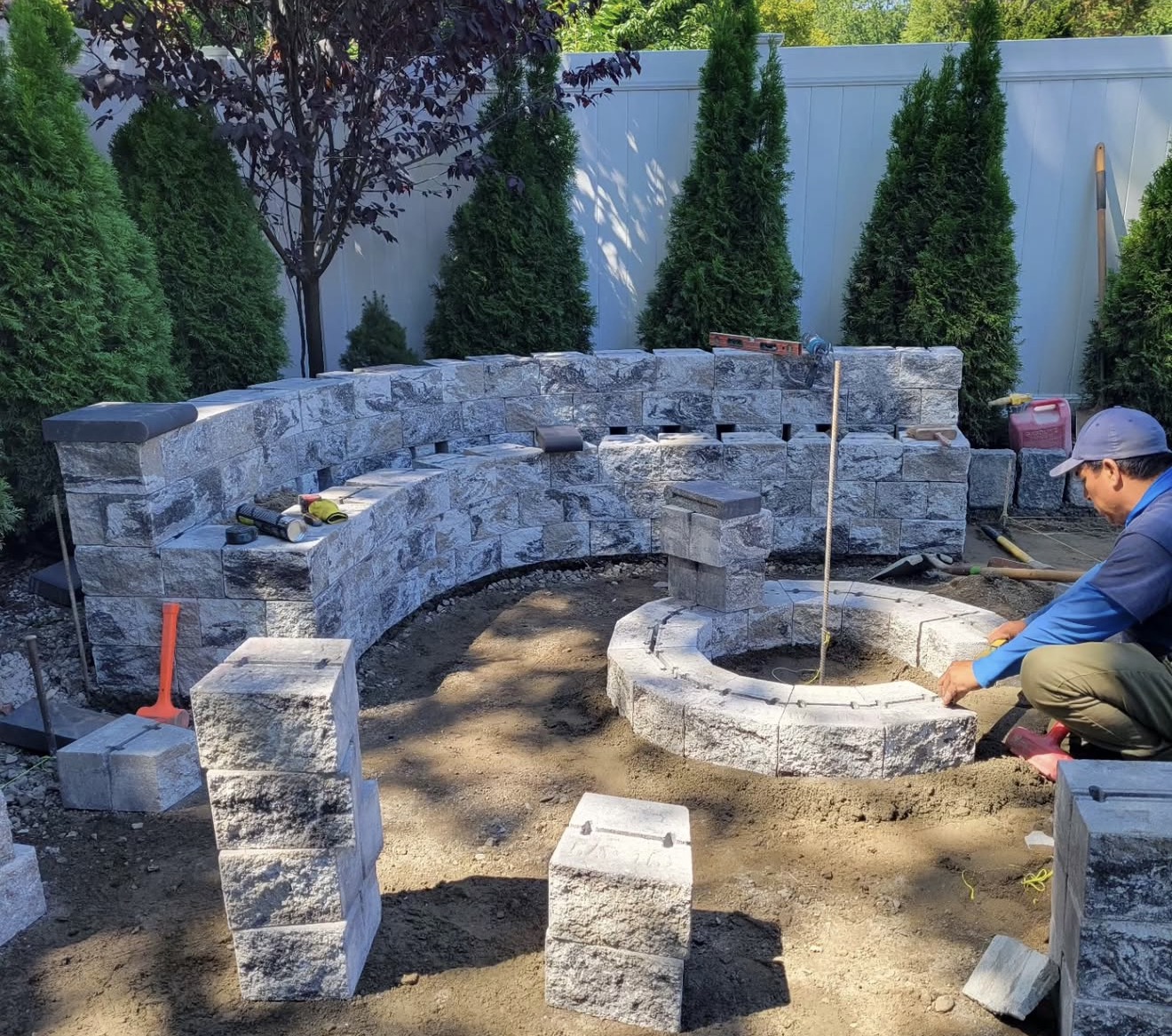 Fibinachi Construction LLC crew building stone seating wall on NYC area job site